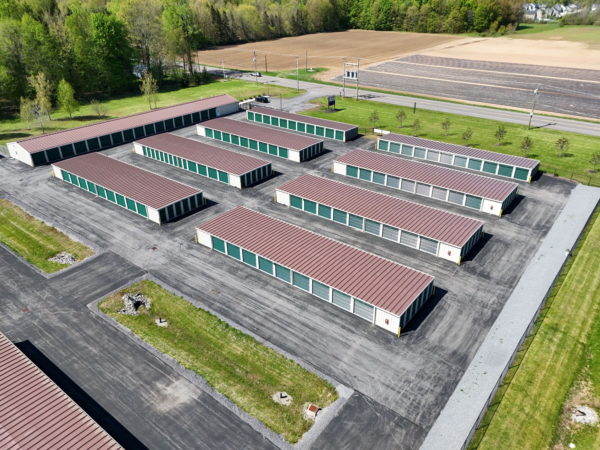 Aerial view of A-Verdi Self Storage facility with rows of storage units, paved driveways, and farmland nearby.